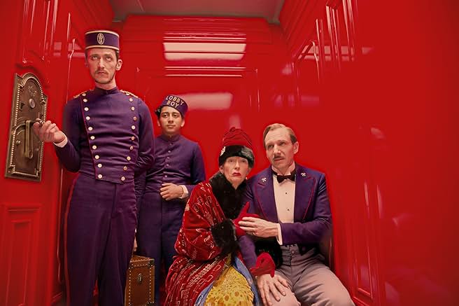Kırmızı otel cephesi ve simetrik kadraj – Wes Anderson sineması