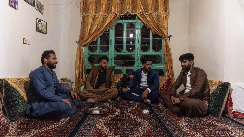 Pirlerin Düğünü belgeselinden ev içinde sohbet eden erkekler bağdaş kurarak yere oturmuşlar.