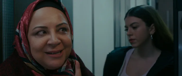 Cam Sehpa (2025) filminden apartman boşluğunda anne kız hesap sormaya geliyor.