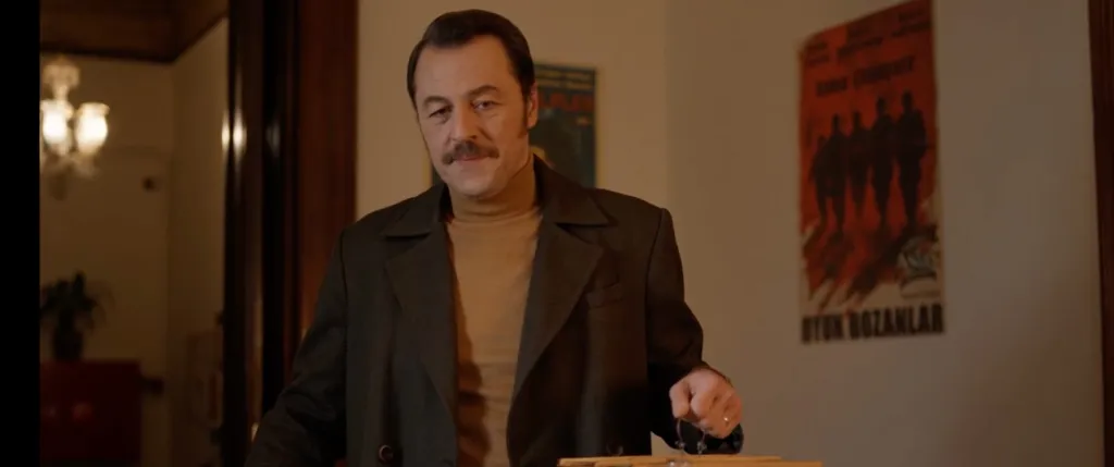Yetkin Dikinciler parçalı yıllar, elinde yemek kapları ve kuş kafesi ile yapımcının odasında. Film Prime Video'da