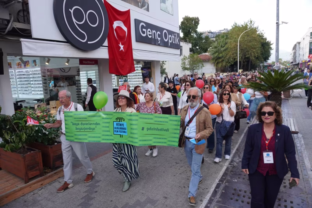 Fethiye Uluslararası Film Festivali’nin açılış etkinliğinden bir görünüm, yürüyüş ve kortej sokakta.